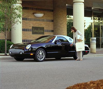 2002 Ford Thunderbird - A woman approaches a black 2002 Ford Thunderbird parked outside a building with a Neiman Marcus sign.