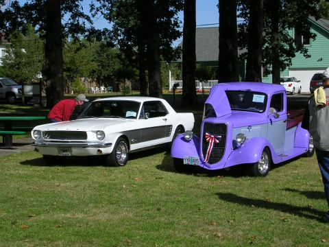 1996 Ford Probe - Two classic vehicles, a Mustang and a custom truck, are displayed on a grassy lawn at an outdoor event.