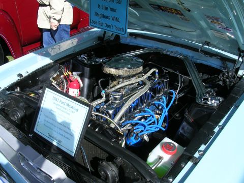 1996 Ford Probe - The engine bay of a light blue 1967 Ford Mustang is displayed, a polished engine and blue spark plug wires.