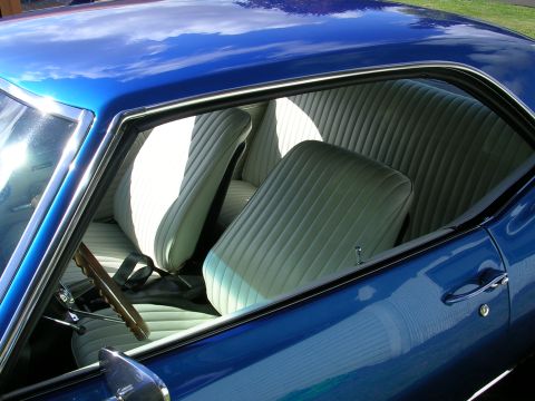1996 Ford Probe - The interior of a blue car shows light-colored pleated seats and a wooden steering wheel.