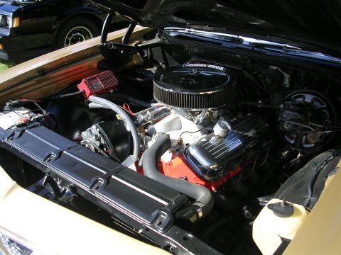 1996 Ford Probe - The engine bay of a classic car is shown, a chrome air cleaner and a red ignition box. Another vehicle is visible in the background.