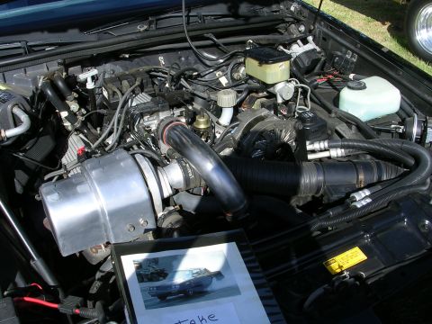1996 Ford Probe - A close-up view of a car's engine bay, with a framed picture of a car resting on the engine components.