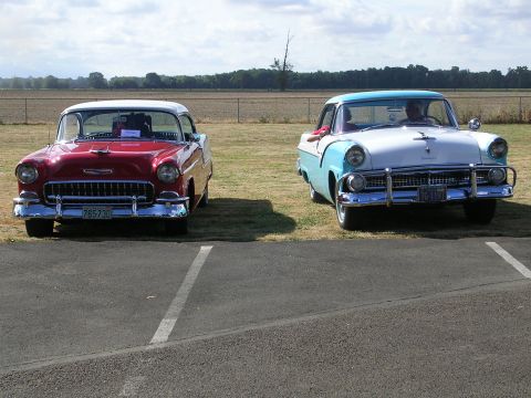 1996 Ford Probe - Two vintage American cars, a red Chevrolet and a blue/white Ford, are parked outdoors.