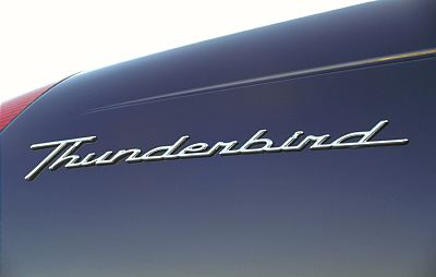 2002 Ford Thunderbird - Close-up of the 'Thunderbird' emblem on the rear quarter panel of a dark blue 2002 Ford Thunderbird.
