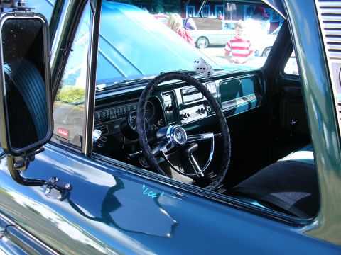 1996 Ford Probe - Interior view of a classic green truck, showing the dashboard, steering wheel, and dice hanging from the mirror.