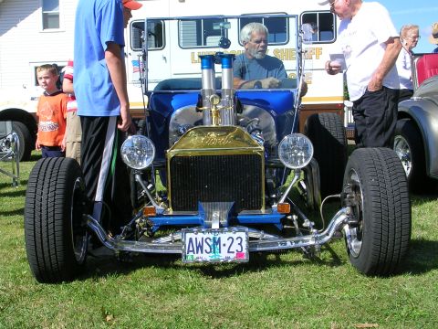 1996 Ford Probe - A custom hot rod is displayed at a car show, with spectators around.