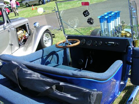 1996 Ford Probe - A custom hot rod with a bright blue interior and a powerful V8 engine is displayed at a car show.