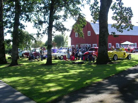 1996 Ford Probe - A sunny day at a car show features various vehicles parked on the lawn in front of a large red barn.