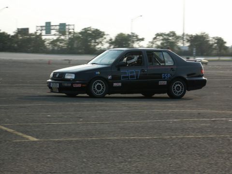 2001 Mercury Grand Marquis - A black Volkswagen Jetta with racing decals is seen on a paved track, possibly during an event.