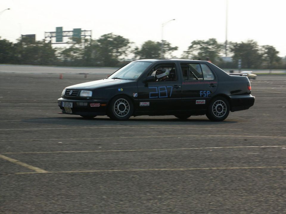 Black Volkswagen Jetta with number 287 on the door, on a race track