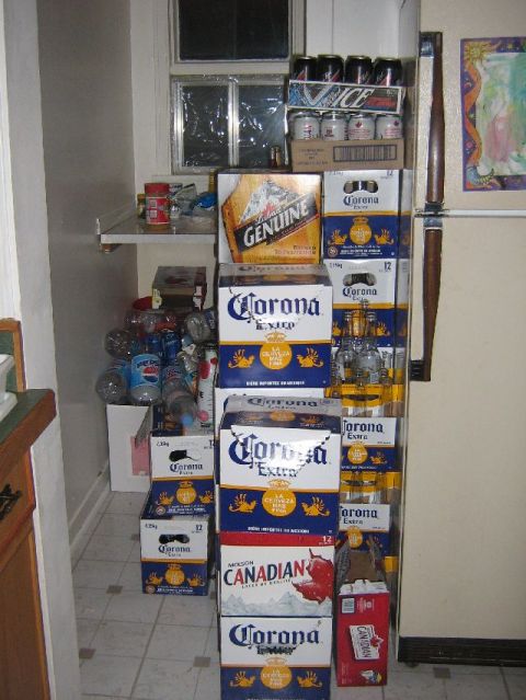 1995 Ford Bronco - A collection of beer and soda boxes are stored in a narrow space next to a refrigerator.