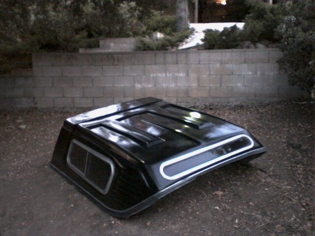 black truck bed cap with chrome trim and tinted windows