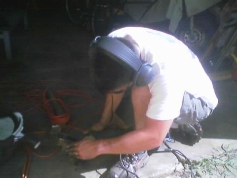 1989 Ford Bronco - Someone is working on a car part in a garage setting with tools and electrical cords.