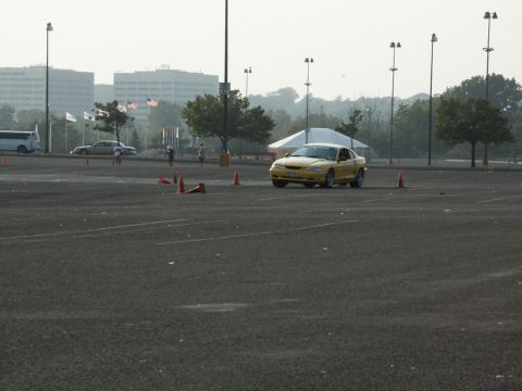 2001 Mercury Grand Marquis - A yellow coupe navigates a course marked by orange cones in a parking lot.