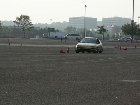 2001 Mercury Grand Marquis - A yellow hatchback navigates a course marked by traffic cones in an open lot.