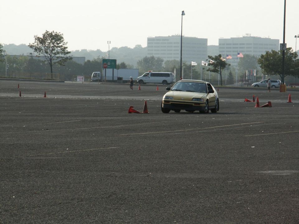 Yellow hatchback car navigating a cone course