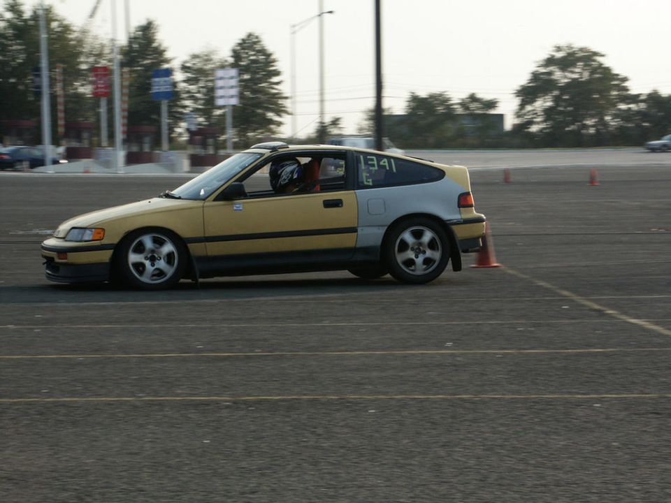 Yellow and silver Honda CRX with racing numbers 1341 G on the rear window, driving on a track