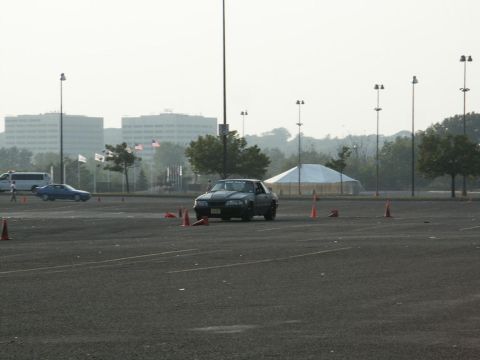 2001 Mercury Grand Marquis - A black sedan navigates a course marked by orange cones in a large parking lot.