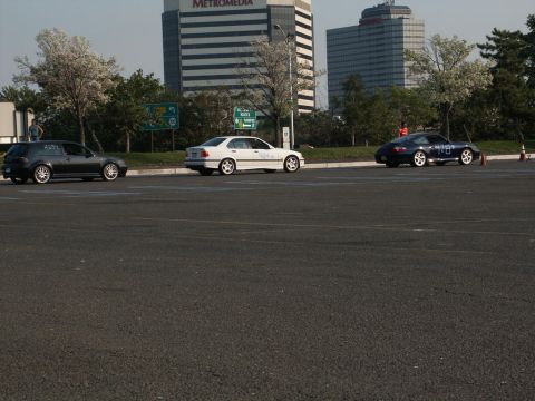 2001 Mercury Grand Marquis - Three cars are lined up in a parking lot with office buildings in the background.