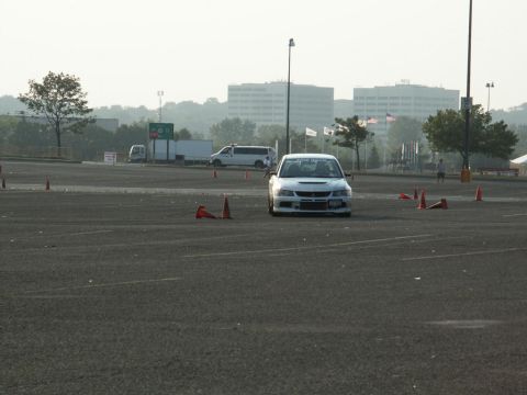 2001 Mercury Grand Marquis - A white sports car navigates a course marked by orange cones in an open paved area.