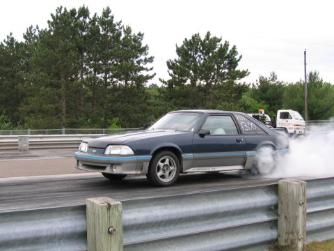 1989 Ford Mustang - A Ford Mustang performs a burnout on the drag strip, creating a cloud of smoke.