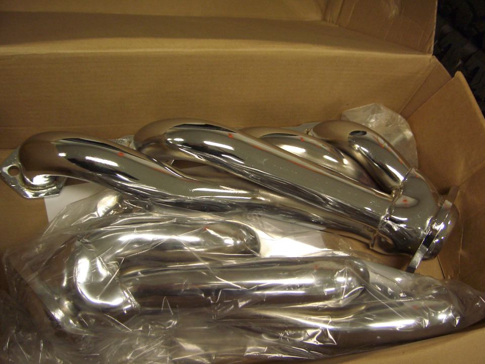 Chrome tubular exhaust headers in a cardboard shipping box