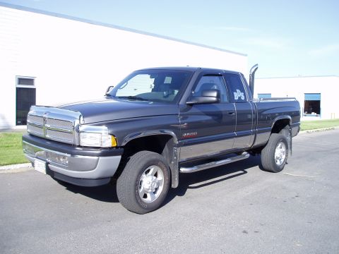 2002 Dodge 2500 - This 2002 Dodge 2500 pickup truck is shown from a 3/4 front angle, a prominent chrome grille and an aftermarket exhaust stack.