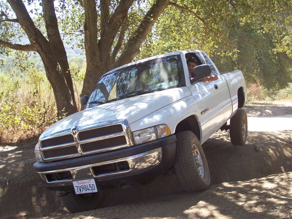 White Dodge Ram pickup truck on a dirt road, 1994-2001 model