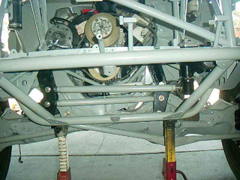 1984 Ford Bronco - Vehicle chassis and engine components are visible, supported by jack stands.