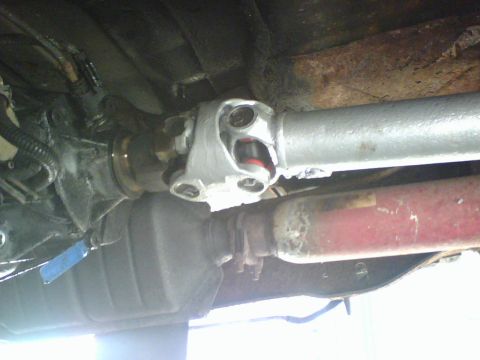1989 Ford Bronco - Underside view of a vehicle's driveshaft and U-joint assembly.