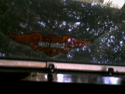 1972 Ford Ranchero - A Harley-Davidson logo is visible on a dark, reflective surface, possibly a vehicle window or panel.