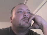1984 Ford Bronco - Close-up of a man with a mustache, deep in thought.