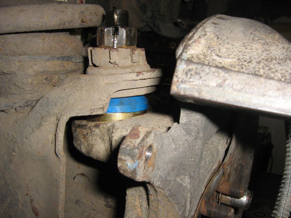close-up of a vehicle's ball joint with a blue and gold bushing