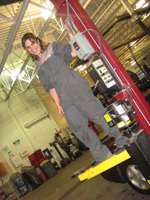 1995 Ford Bronco - A mechanic is shown operating a vehicle lift in a garage setting.