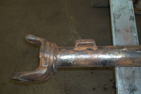 1983 Ford Bronco - Close-up view of a heavily rusted driveshaft yoke and U-joint flange, likely a replacement part.