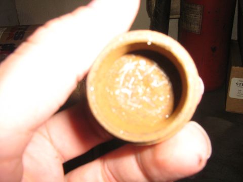 1995 Ford Bronco - A close-up view of a cap filled with greasy residue, held by a hand.