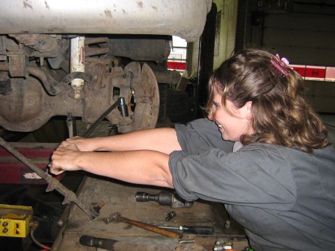 1995 Ford Bronco - A person works on the suspension components of a vehicle in a garage setting.