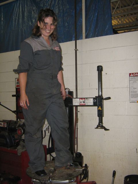 1995 Ford Bronco - A mechanic poses with a tire changing machine in a garage setting.