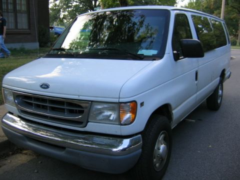 1994 Ford Bronco - A white van is parked on a street, seen from a 3q-front angle.