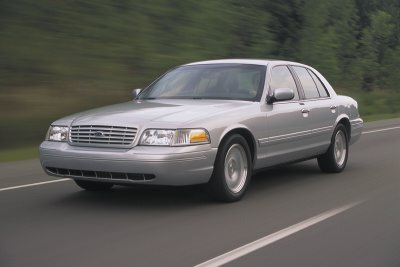 2002 Ford Crown Victoria - A silver 2002 Ford Crown Victoria sedan is captured in motion on a highway.