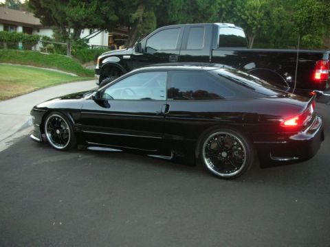 1994 Ford Probe - A black 1994 Ford Probe is shown parked on a street, with a black pickup truck behind it.