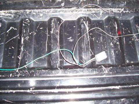 2003 Ford Ranger - Wiring harness with a white connector is visible in the scratched bed of a truck.