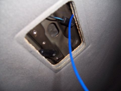 2003 Ford Ranger - Close-up view of exposed wiring and a blue cable within a vehicle's interior ceiling light fixture opening.