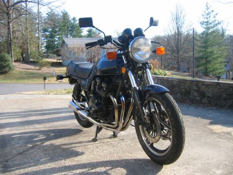 1985 Ford LTD Crown Victoria - Motorcycle parked outdoors on a sunny day.