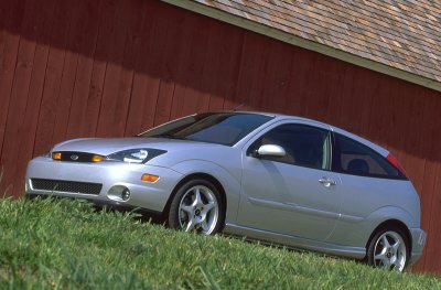 2002 Ford Focus - A silver 2002 Ford Focus SVT is shown from the front three-quarter view, parked on grass beside a red building.