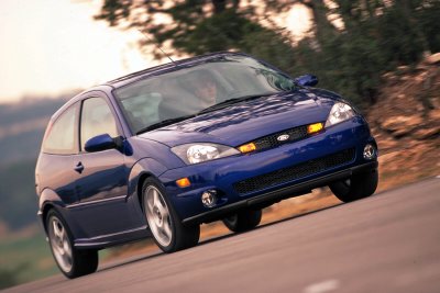 2002 Ford Focus - A blue 2002 Ford Focus SVT is captured in motion on a winding road, its sporty design.