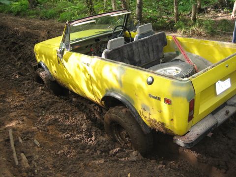 1997 Dodge 1500 - This yellow convertible is stuck in the mud while off-roading, with Scout II badging visible on the rear.