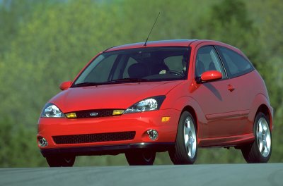 2002 Ford Focus - A red 2002 Ford Focus SVT is captured in a three-quarter front view while driving on a road.