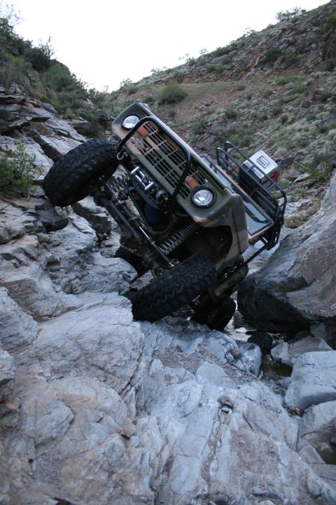 1966 Ford Bronco - Ford Bronco navigating difficult rocky terrain, tilted at an angle.