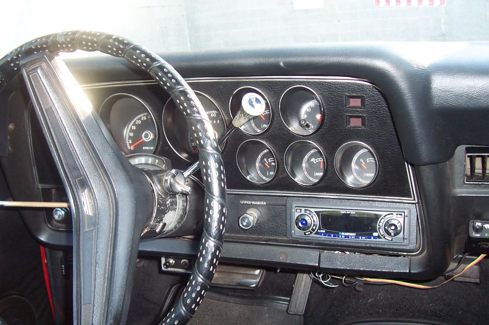 Car interior dash with round gauges, wrapped steering wheel, and Blaupunkt stereo